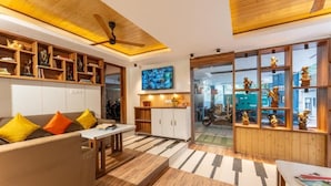 A modern living room with a sofa, coffee table, and wooden shelves. - ZoukStayz (Rishikesh)