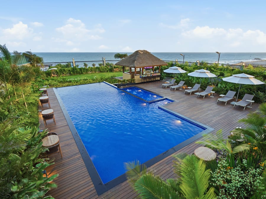 Una piscina al aire libre, sombrillas, sillones reclinables de piscina