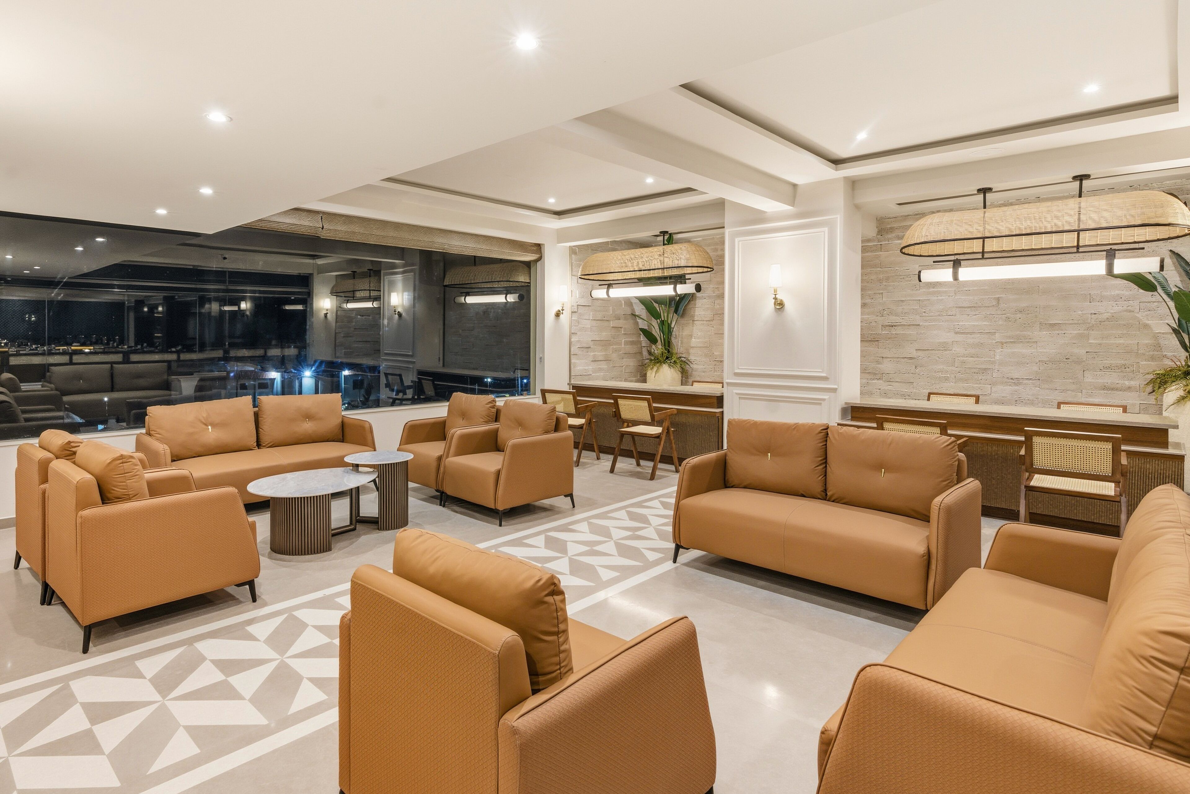 A modern lobby with sofas, a reception desk, and a bar area.