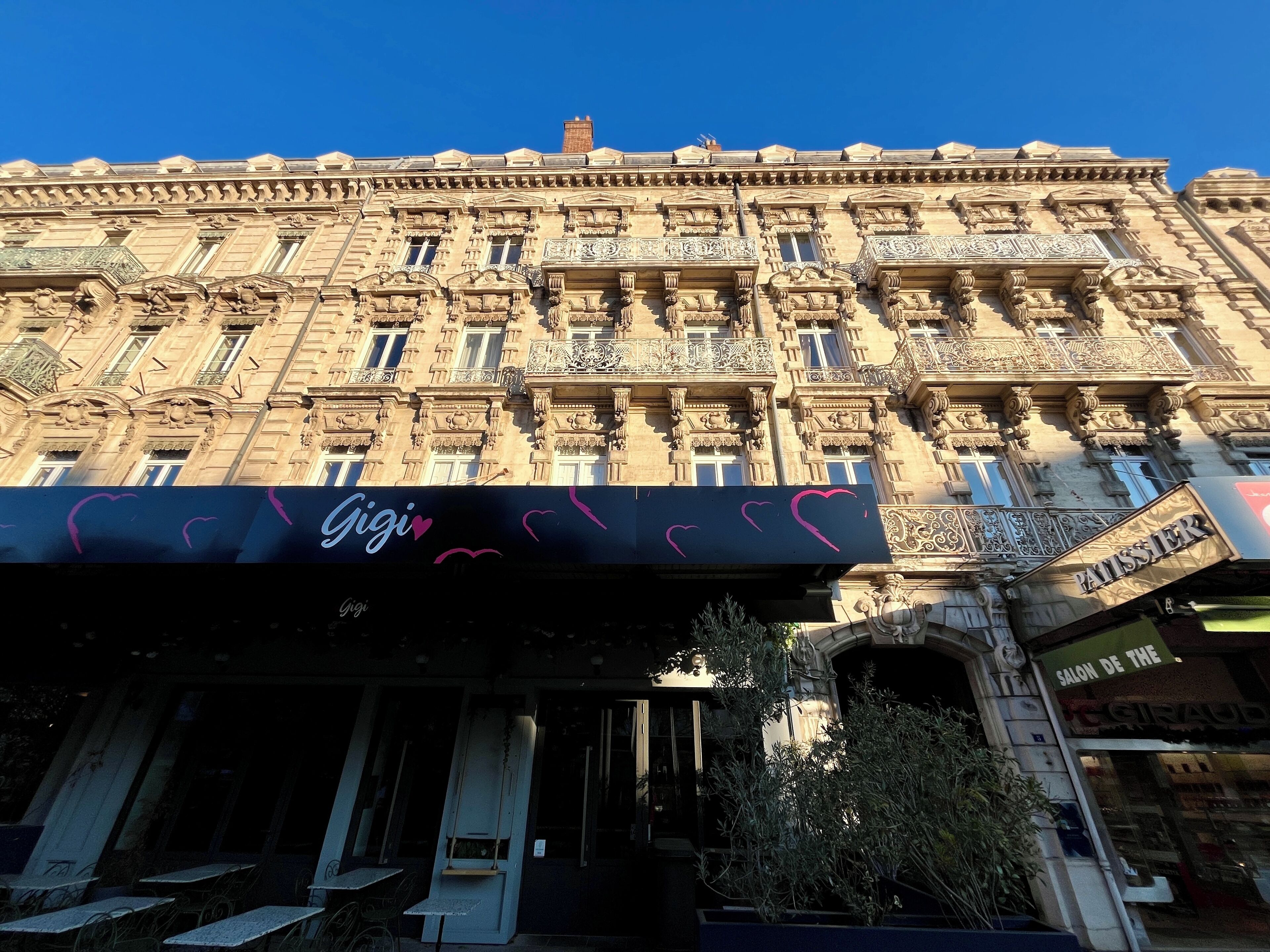Un bâtiment historique doté d’éléments architecturaux raffinés, notamment des balcons et des moulures décoratives.