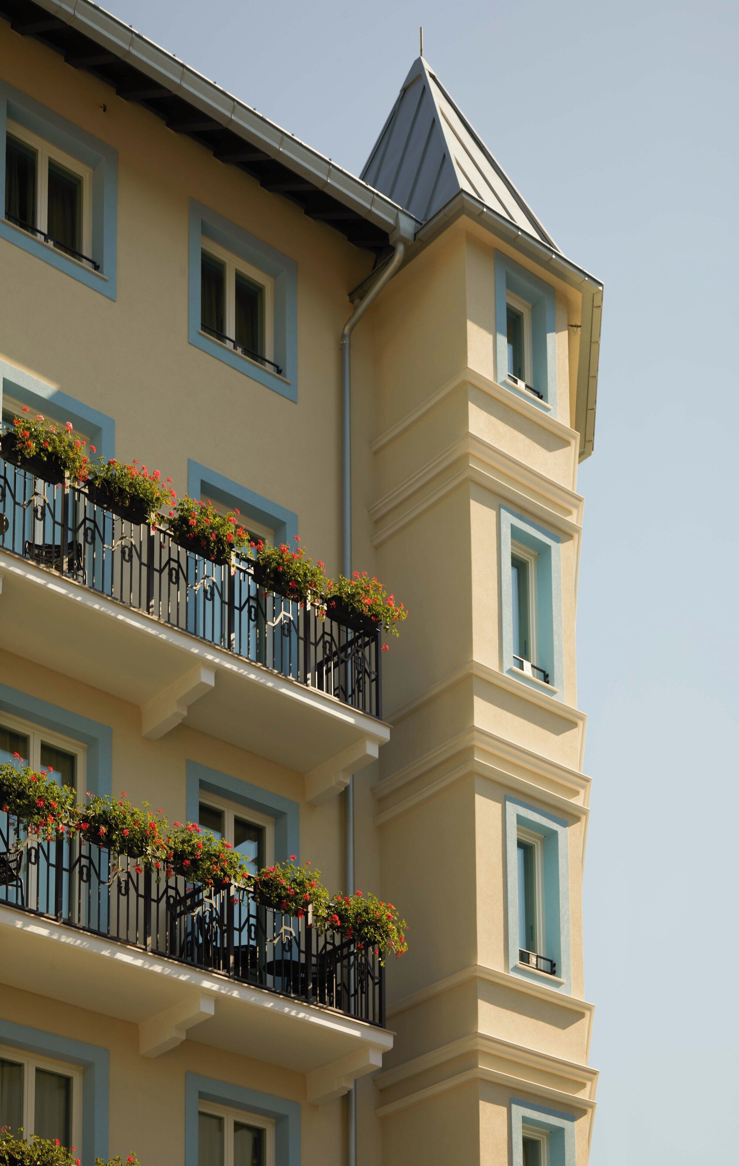 Un immeuble à plusieurs étages doté de balcons ornés de jardinières.