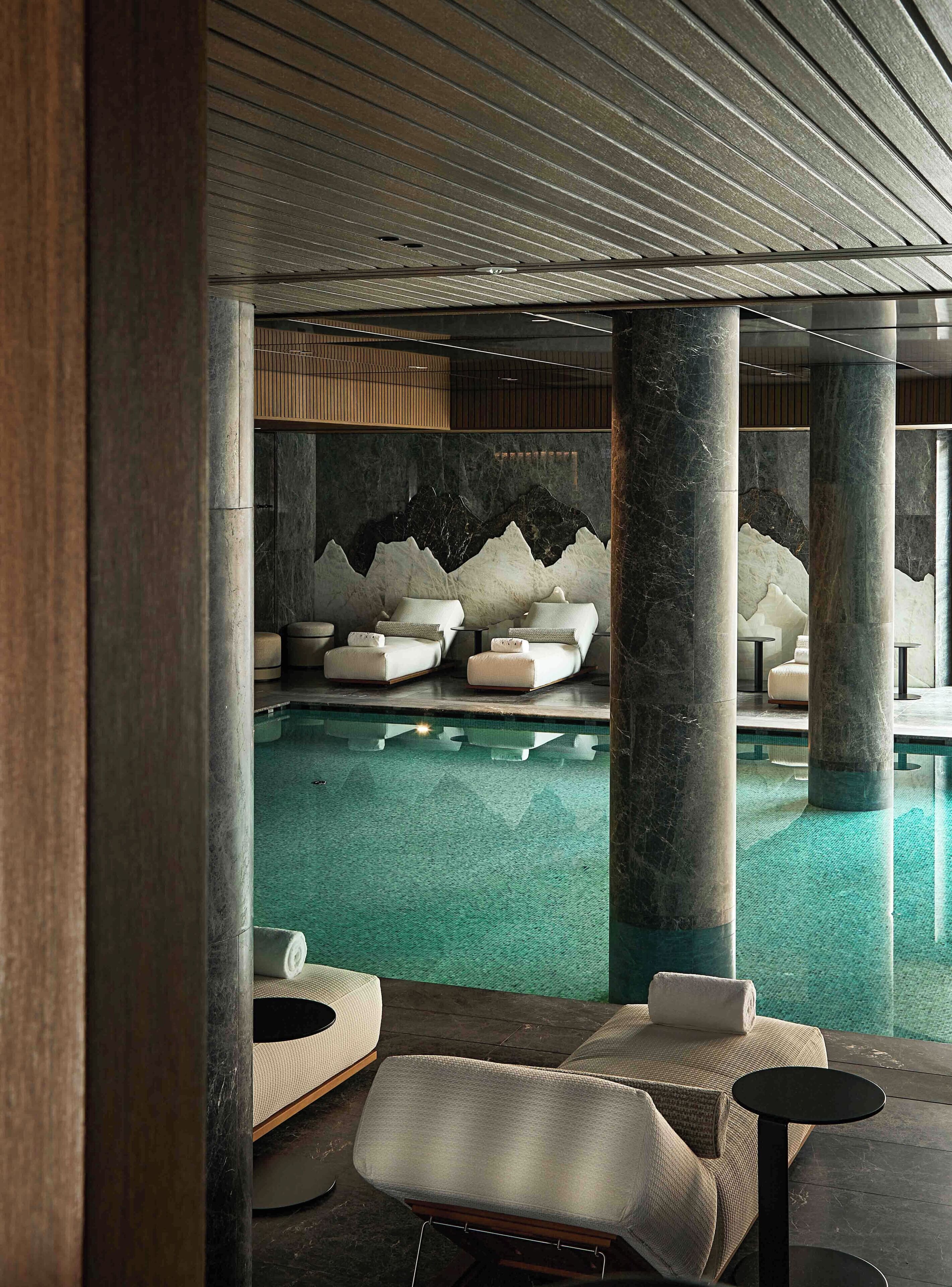 Ein Spa-Bereich mit Pool, Liegestühlen und einer Sitzecke mit Blick auf den Pool.