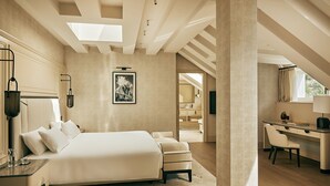 Un dormitorio con una cama grande, un escritorio y un baño visible a través de una puerta abierta.