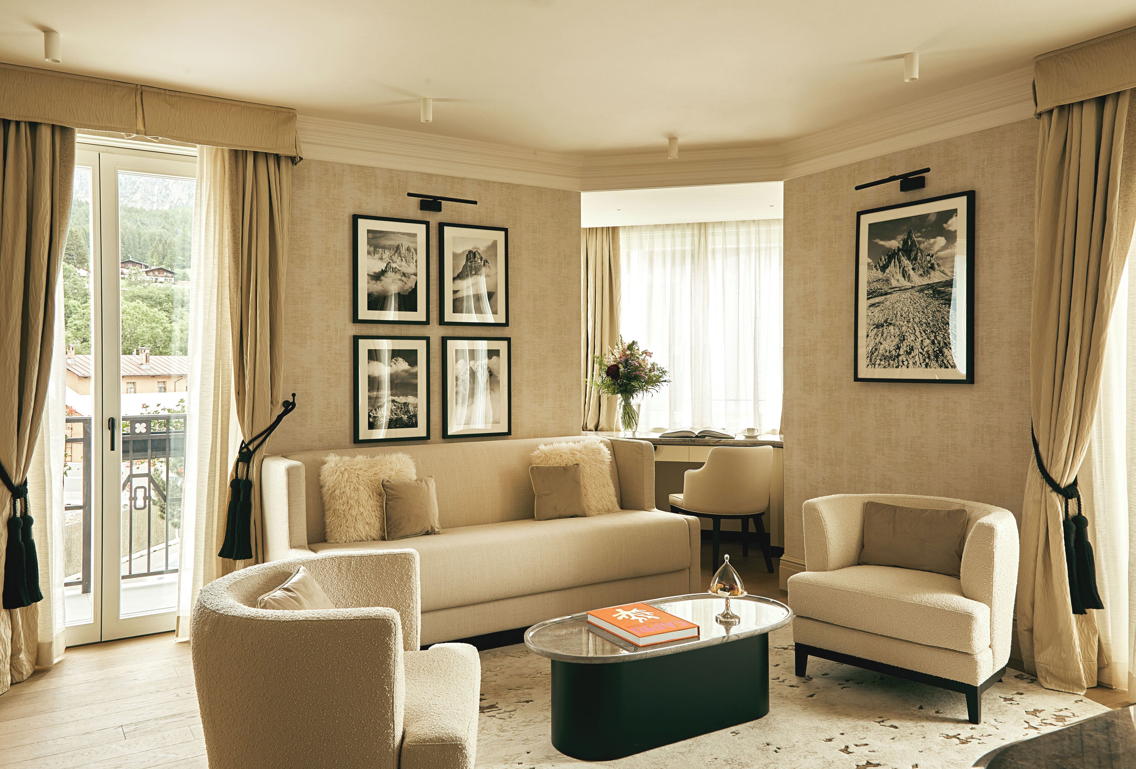Un salon comprenant un canapé, deux fauteuils, une table basse et des tableaux encadrés accrochés au mur.