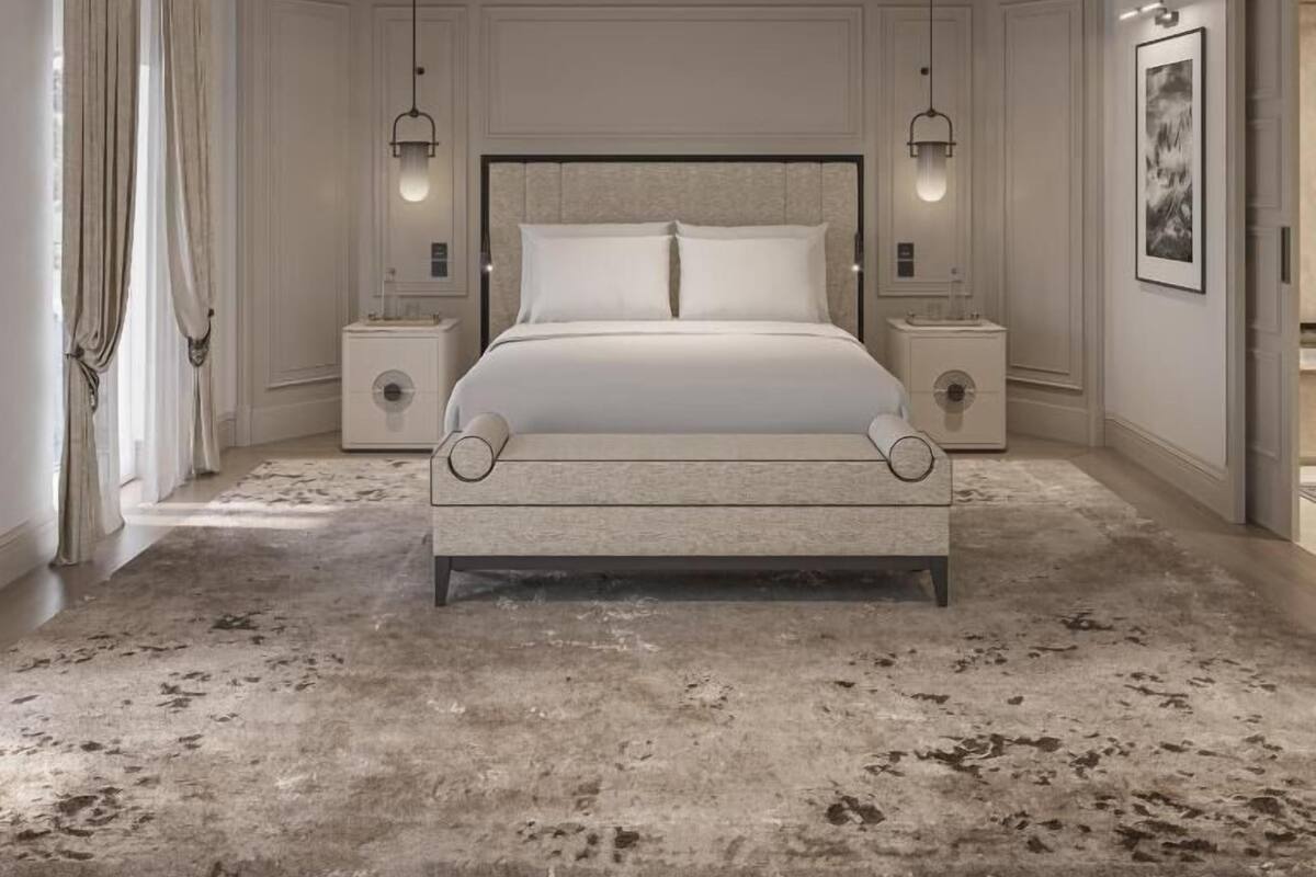 Un dormitorio con una cama grande, dos mesitas de noche, un cabecero y un cuadro enmarcado en la pared.