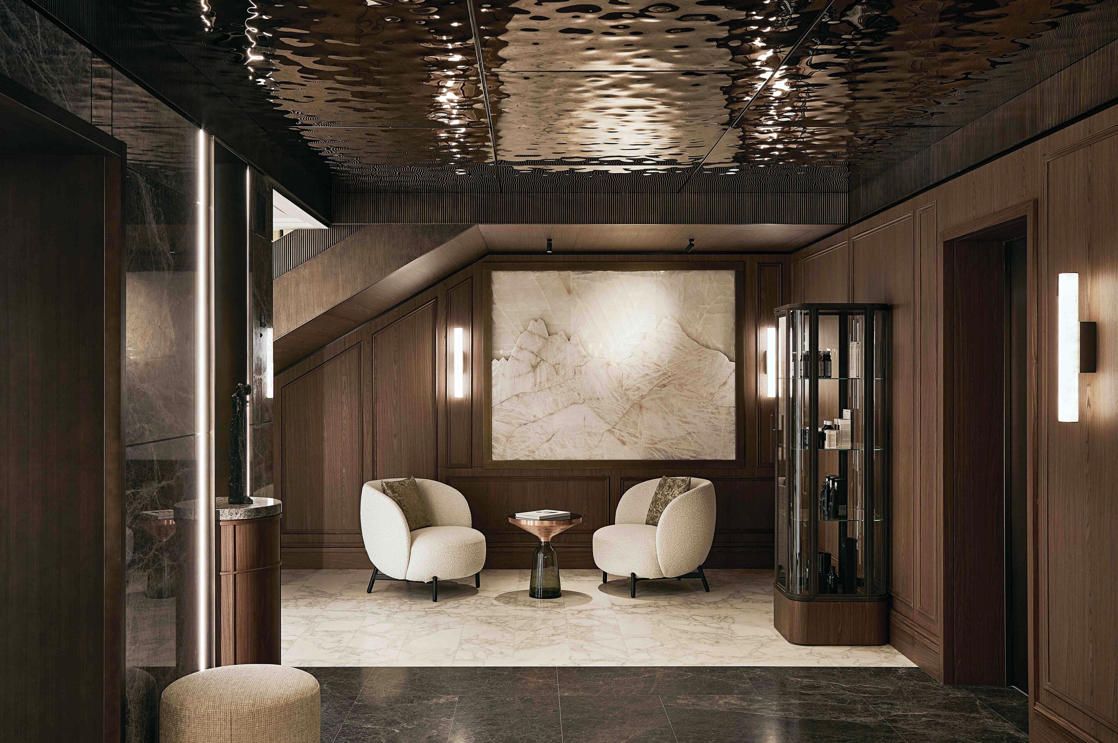 A modern interior with a marble floor, two armchairs, a coffee table, and a large abstract painting on the wall.
