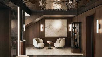 A modern interior with a marble floor, two armchairs, a coffee table, and a large abstract painting on the wall.