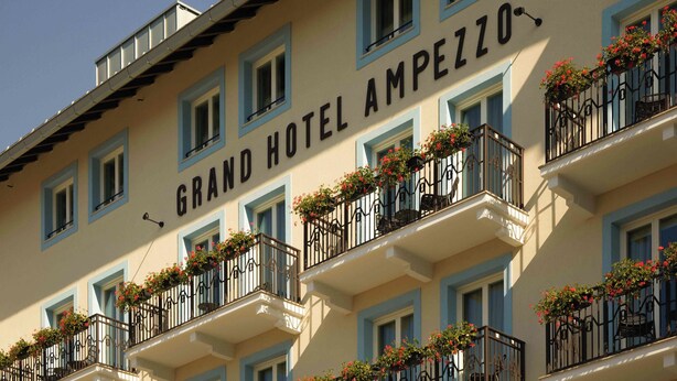 Un edificio de hotel con múltiples balcones decorados con jardineras de flores.