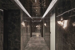 A corridor with marble walls and a reflective ceiling, leading to a room labeled 'Cafés'. - Grand Hotel Ampezzo (Cortina d'Ampezzo)