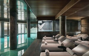 Una piscina techada, sillones reclinables de piscina