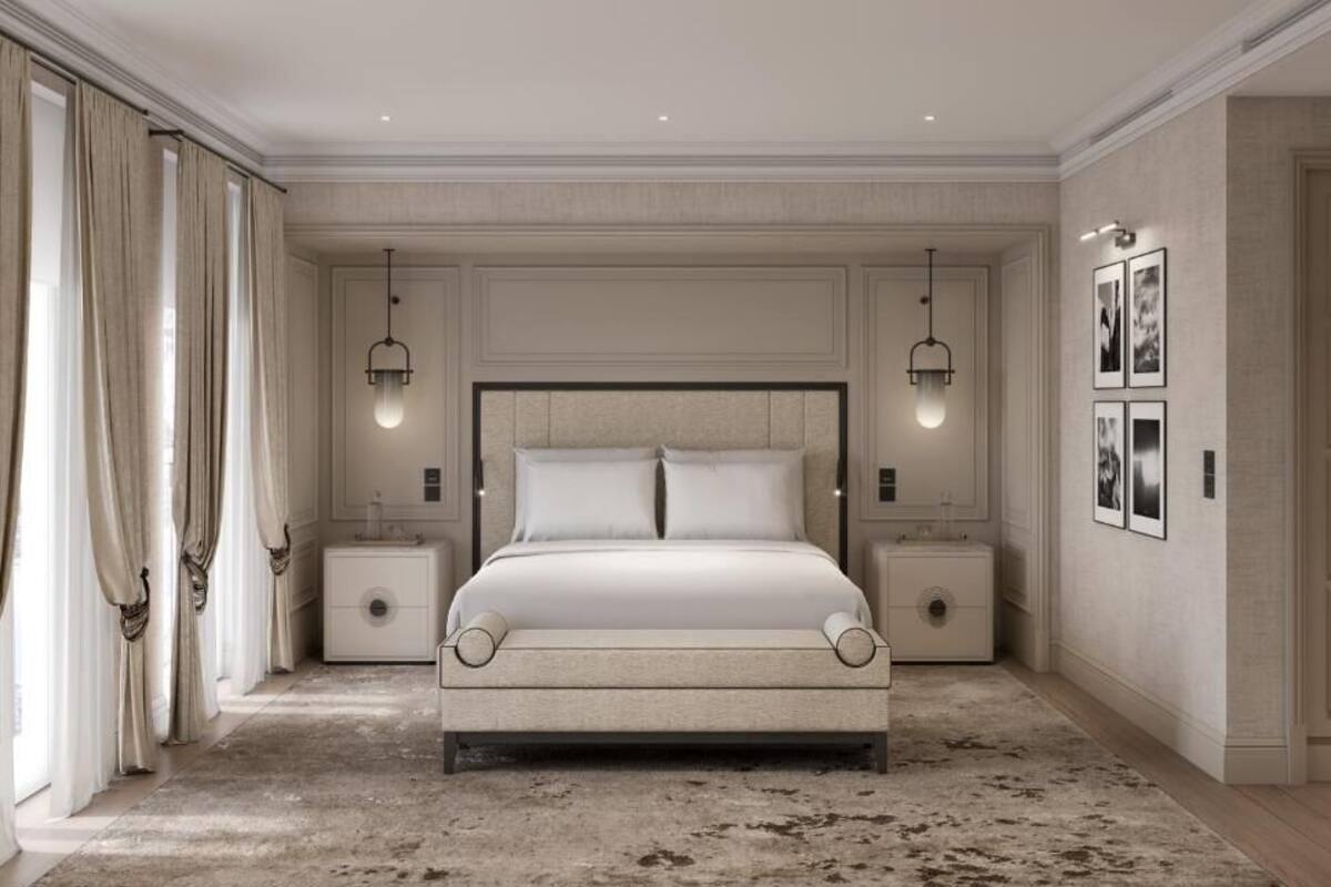 Un dormitorio con una cama grande, dos mesitas de noche, una alfombra y un cuadro en la pared.