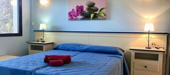 Elegant 19 sq m room featuring a double bed or two single beds and a private bathroom with shower, bidet, and hairdryer. The room also features an outdoor space with a sea view, a patio or terrace, furnished with a table and chairs. Breakfast is included