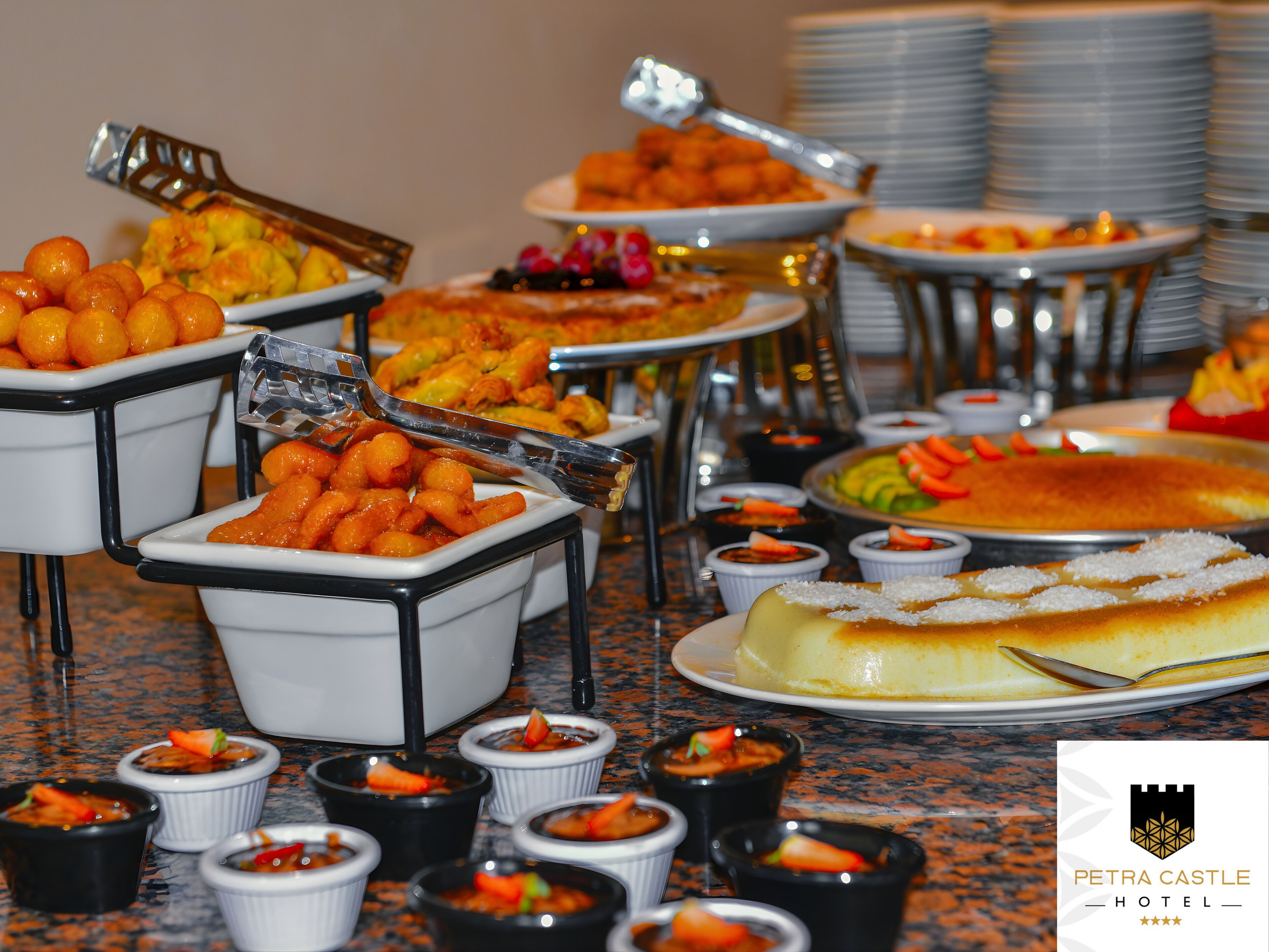 A buffet with various dishes, including a large cheesecake and several small bowls of food.