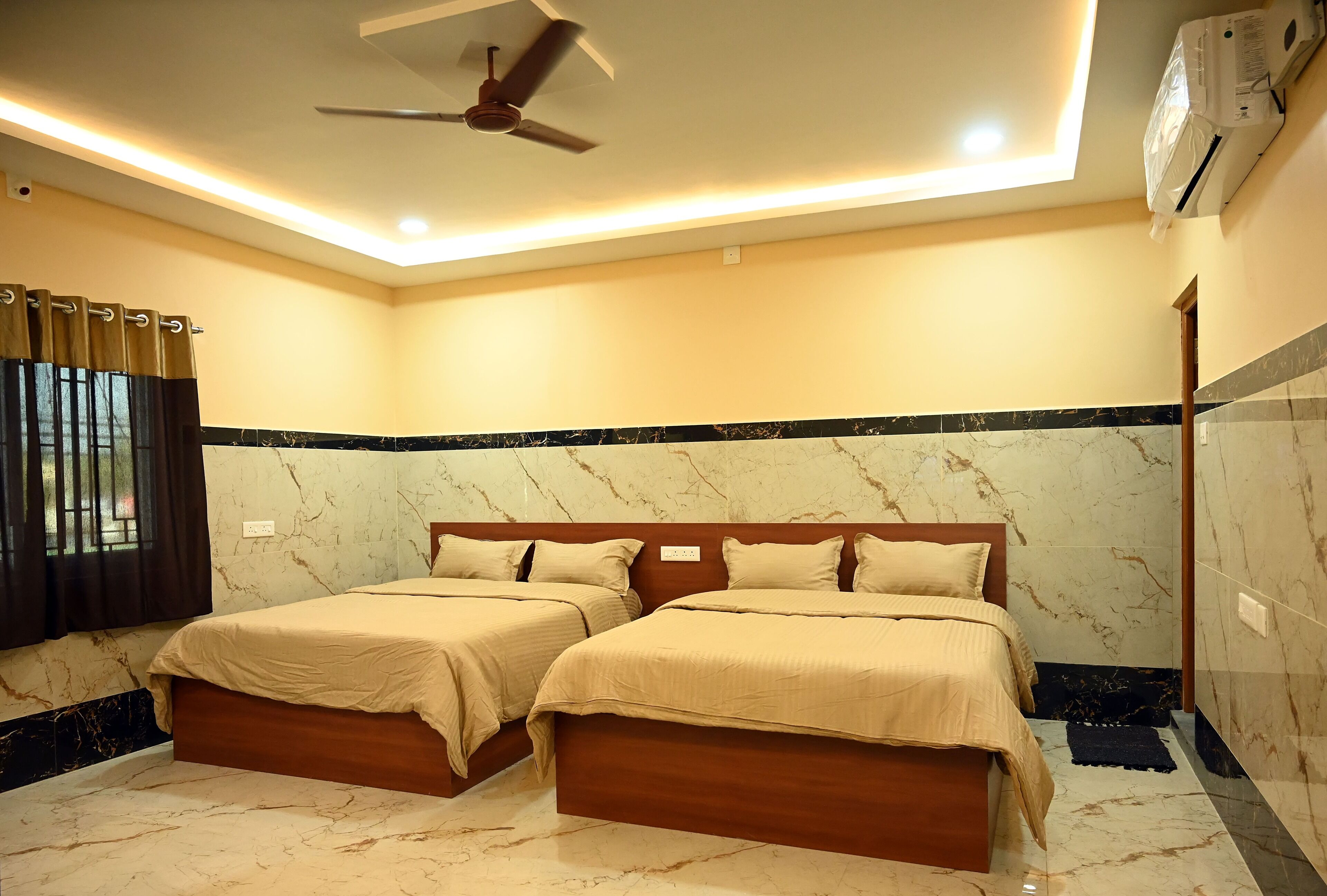 A hotel room with two beds, a ceiling fan, recessed lighting, and marble flooring.