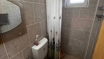 Chuveiro, secador de cabelo, toalhas de banho, papel higiênico