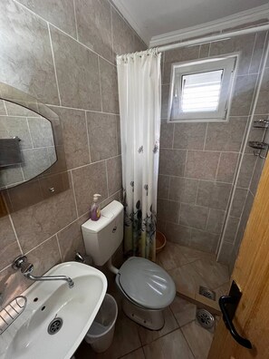 Een douche, een haardroger, handdoeken, toiletpapier