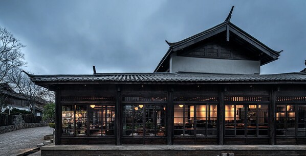 A traditional wooden building with a tiled roof and large windows. - Lijiang Old Town Lanshe Hotel (Lijiang)