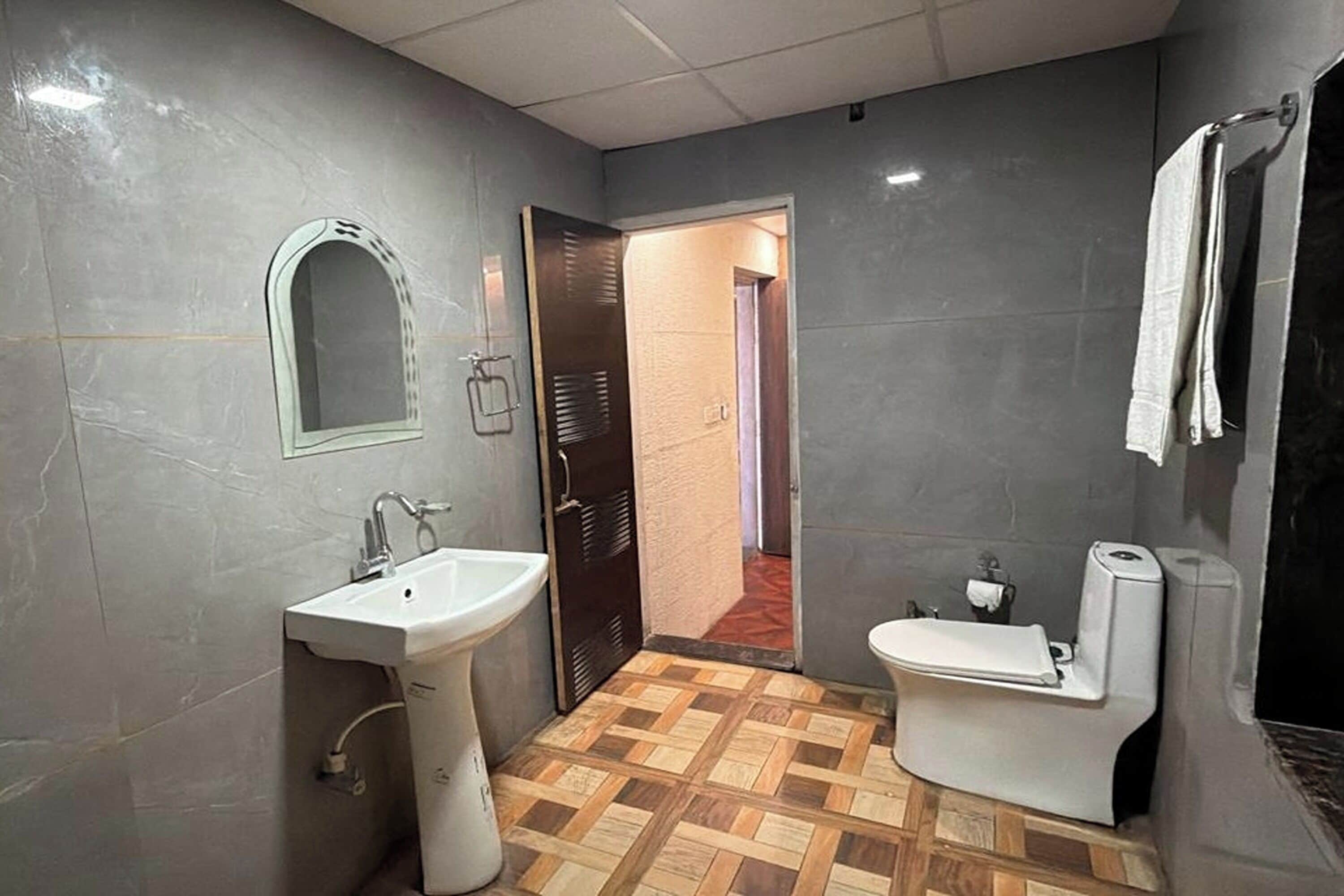 A bathroom with a sink, toilet, and mirror.
