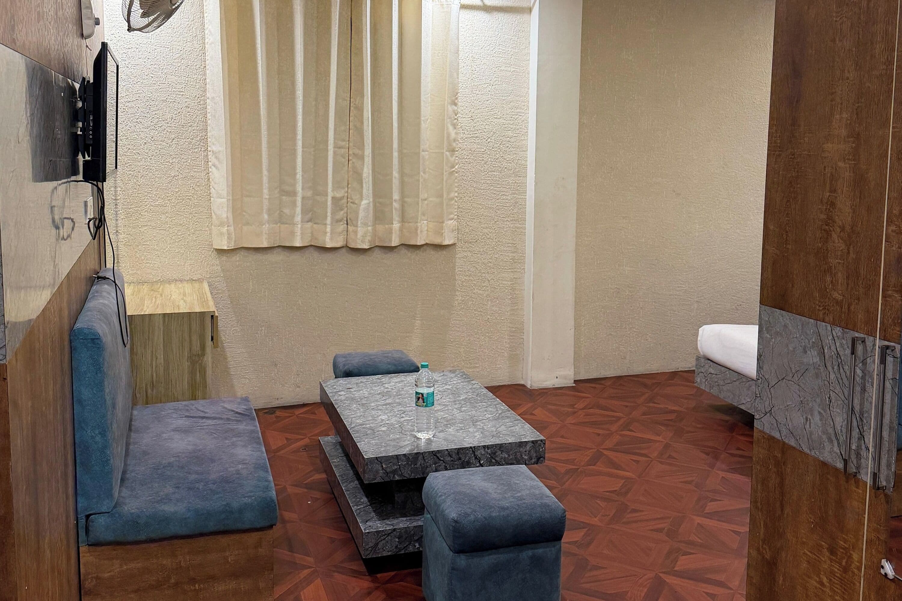A small, modern room with a sofa, a table, and a bench.