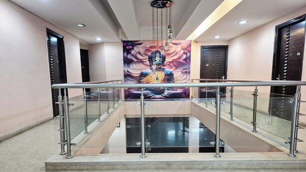 A modern interior with a glass railing, a Buddha mural, and a polished floor. - Premium Nest, Golf Course Road (Gurugram)