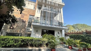 A modern building with a balcony and a sign indicating "Rooms Available." - Premium Nest, Golf Course Road (Gurugram)