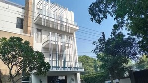 A multi-story building with a modern architectural design, featuring balconies and a flat roof. - Premium Nest, Golf Course Road (Gurugram)