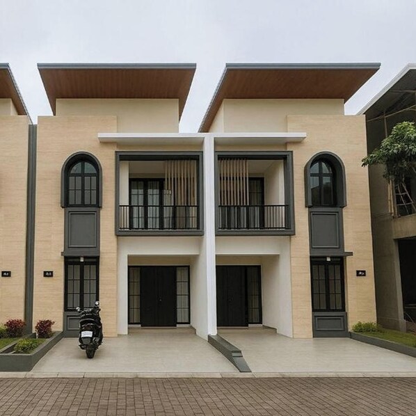 Un edificio moderno a due piani con facciata simmetrica, ampie finestre e un ingresso centrale.