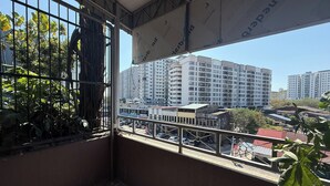 A balcony with a view of high-rise buildings, a metal railing, and some greenery. - Aikka Hotel (Butterworth)
