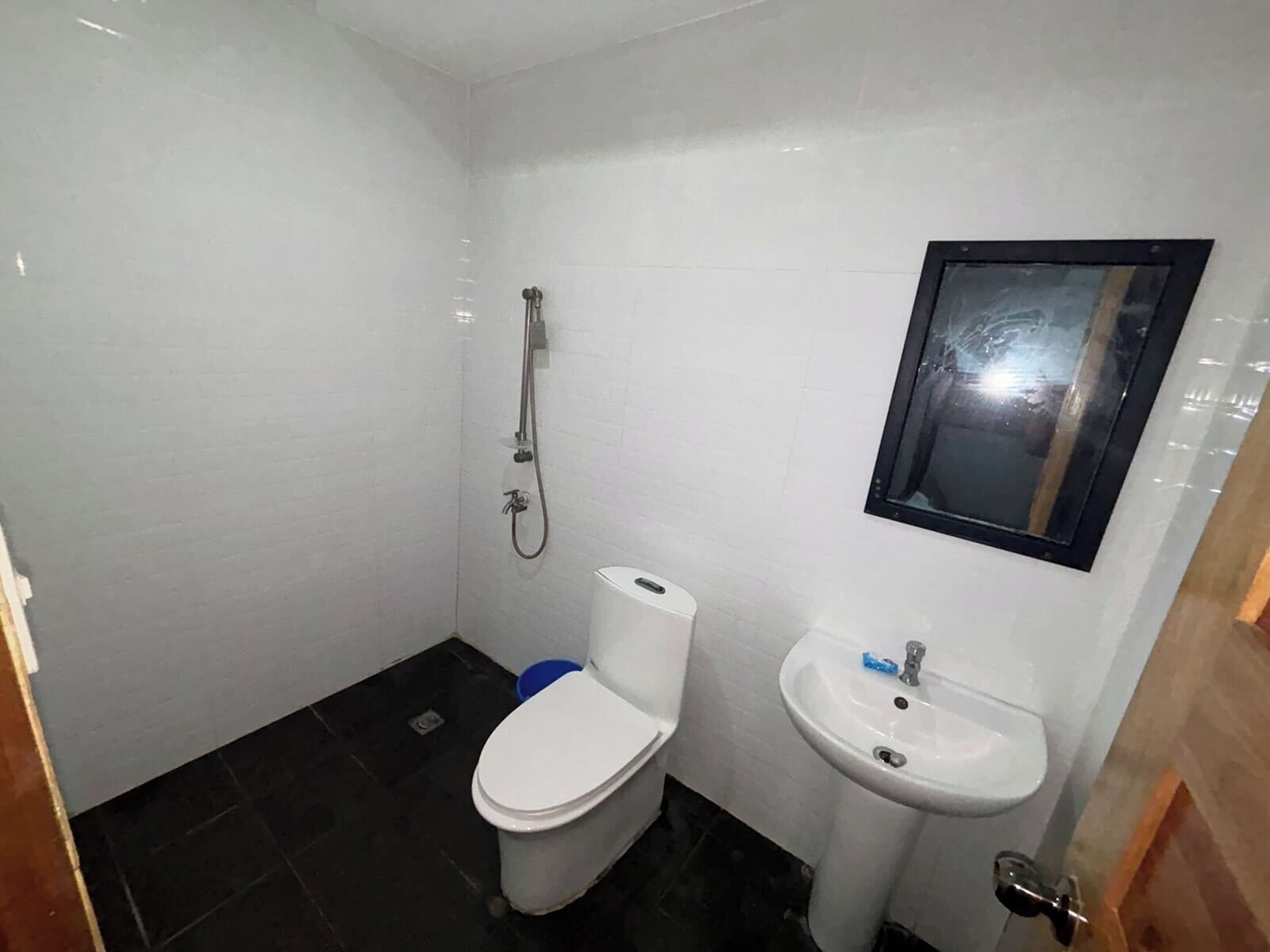 Un baño pequeño y limpio con inodoro, lavabo y ducha.