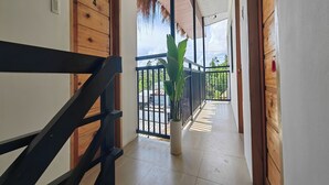 A wooden staircase leading to a balcony with a potted plant. - Eva'S Guest House (General Luna)
