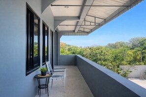 Ein Balkon mit Blick auf eine üppige, grüne Landschaft.