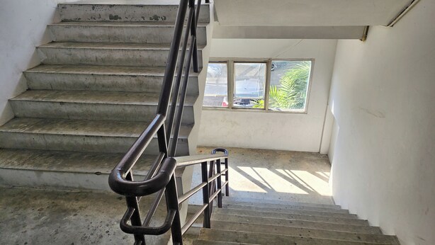 Eine Treppe mit Metallgeländern, die zu einer Zwischenebene führt.