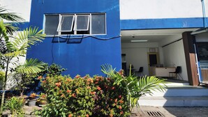 Ein Gebäude mit blauer Fassade, einem Fenster und einer Rezeption mit Sitzgelegenheiten und einem Empfangstresen.