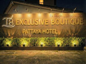 Exterior del hotel Pattaya con señalización iluminada.