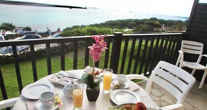 Functional 28 sq m room.Comprising a double bed, two single beds, and a private bathroom with shower, bidet, and hairdryer. The room also features an outdoor space with a sea view, a patio or terrace, and a table and chairs. Breakfast is included in the