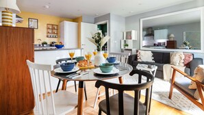 Un salon moderne avec un coin repas, comprenant une table ronde, des chaises et un canapé.