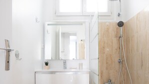 A modern bathroom with a white vanity, a large mirror, a shower with a handheld showerhead, and a bathtub. - Luxembourg Gardens Cosy Studio - Paris 5th (Paris)