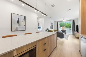 Une cuisine moderne dotée d’un îlot central, de meubles en bois et d’un coin repas avec des chaises.