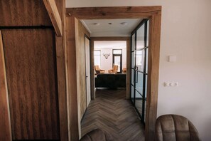 A hallway with wooden flooring and glass doors leading to a dining area with chairs and a table. - Luxury country home (sleeps 10) with a hot tub and unobstructed views of the countryside (Rheeze)