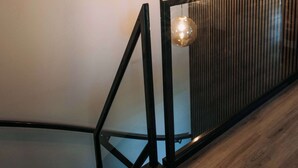 Un escalier moderne avec une finition en bois et des rampes en verre.