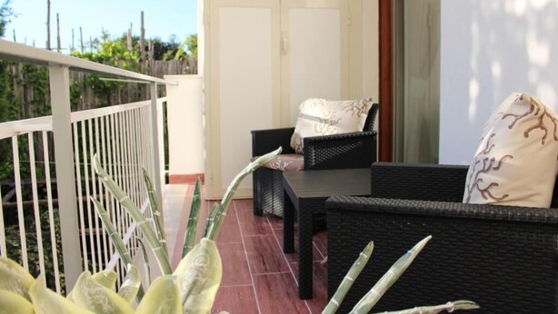 A balcony with wicker furniture and a potted plant. - La Casa Degli Amici (Sorrento)