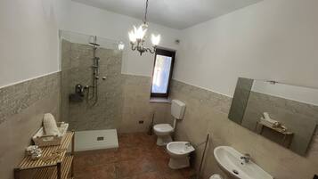 Un baño con ducha, inodoro, bidé y lavamanos.