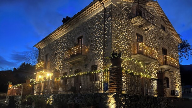 A stone building with balconies, a stone wall, and a paved area. - B&B Villa Maria (Marano Principato)