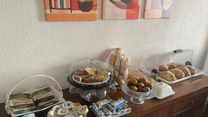 A buffet table with various food items, including bread, pastries, and packaged snacks. - B&B Villa Maria (Marano Principato)