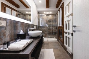 A modern bathroom with a large vessel sink, a walk-in shower, and a wooden ceiling. - MALVASIA SUITE (Venezia)