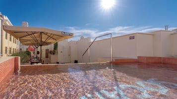A rooftop pool area with a sun umbrella labeled 'SLEEPN' and a staircase leading to an upper level.