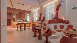 A modern interior with a bar area, seating arrangements, and decorative wall art. - SLEEPN Valencia (Valencia)