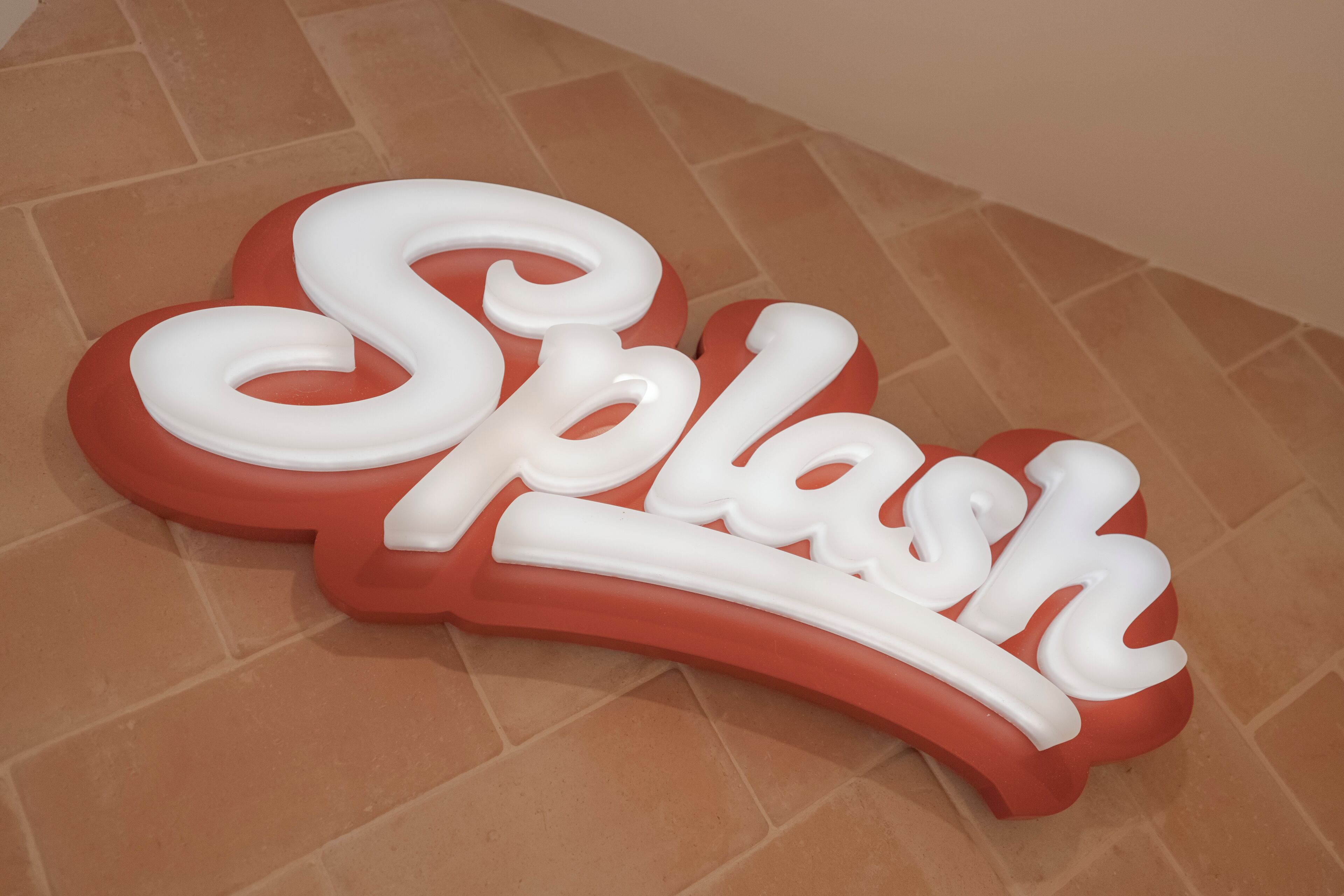 A red and white sign with the word 'Splash' in a playful font.