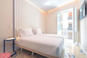 A bedroom with a bed, a bedside table, a power outlet, and a view of the outside balcony. - SLEEPN Valencia (Valencia)