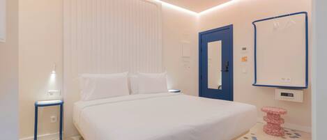 A bedroom with a bed, bedside table, and a wall-mounted mirror.